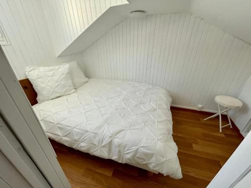 Dormitorio pequeño con cama blanca en el ático en Appartement idéalement situé Ax-les-thermes, en Ax-les-Thermes