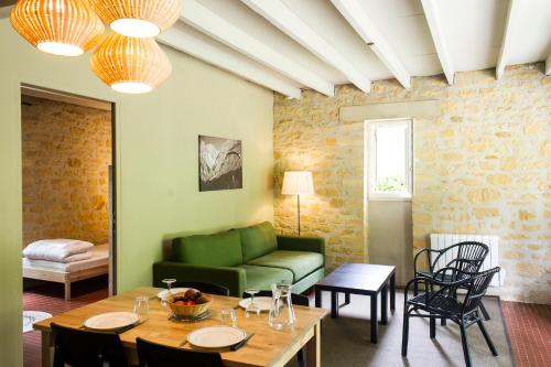 un salon avec un canapé vert et une table dans l'établissement Les gites de Sarlat, à Sarlat-la-Canéda
