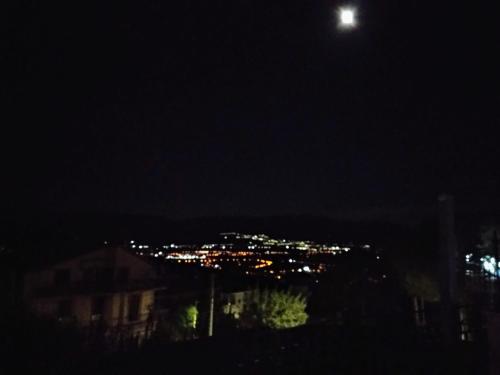a view of a city at night with the moon at affittacamere rezzo in Monte San Giacomo