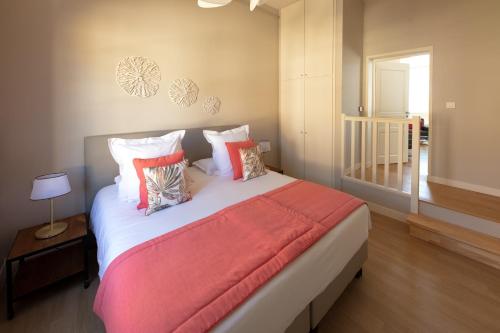 a bedroom with a large bed with colorful pillows at Le Rempart du Midi in Angoulême