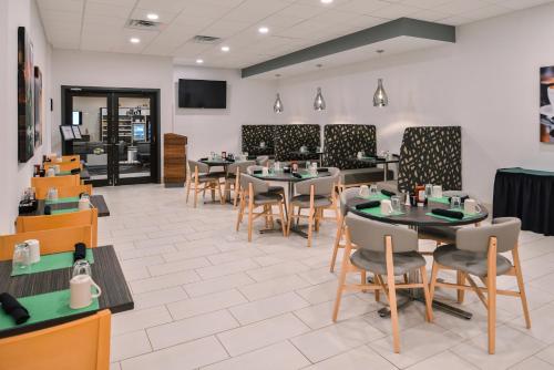 Un comedor con mesas y sillas en un restaurante. en Holiday Inn Auburn-Finger Lakes Region by IHG, en Auburn