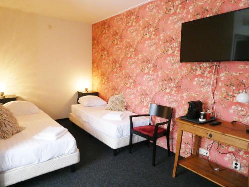 a hotel room with two beds and a flat screen tv at Hotel Café Restaurant De Posthoorn in Dokkum