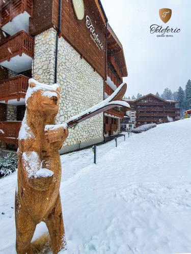 a statue of a bear holding a pair of skis at Teleferic Grand Hotel in Poiana Brasov