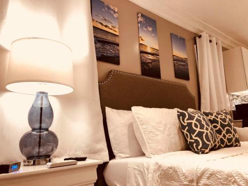 a bedroom with a bed and a lamp on a table at Elegant Marble Suite #6 in Nassau