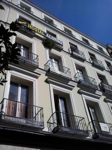 a large white building with balconies and a sign on it at Hostal Alonso No Limit Madrid in Madrid