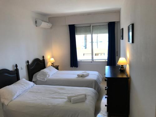 Habitación de hotel con 2 camas y ventana en Apartment MAKAI, en Estepona