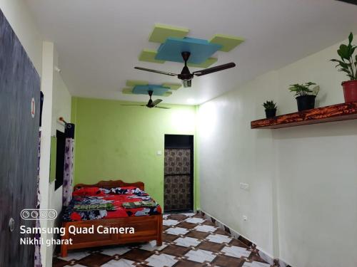 1 dormitorio con ventilador de techo y 1 cama en Sai Ram Cottage, en Alibaug