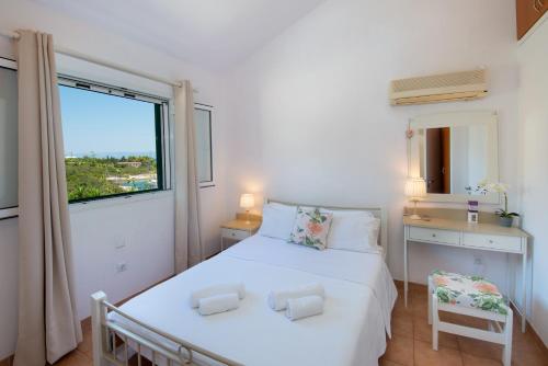 una camera da letto con un grande letto bianco e una finestra di The Kantada Villas Petros, Eleni, Stelios & Dioni a Gaios