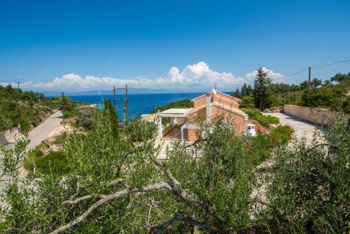 a house on a hill with the ocean in the background at The Kantada Villas Petros, Eleni, Stelios & Dioni in Gaios