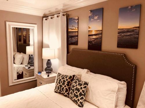 1 dormitorio con 1 cama con 2 espejos en la pared en Elegant Marble Suite #6, en Nassau