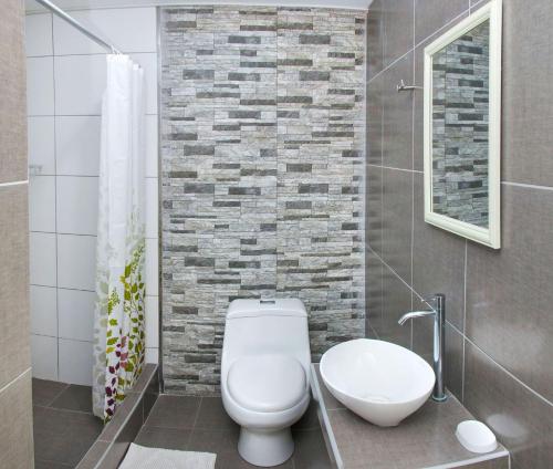 a bathroom with a white toilet and a sink at El Huerto Hostel in Ica