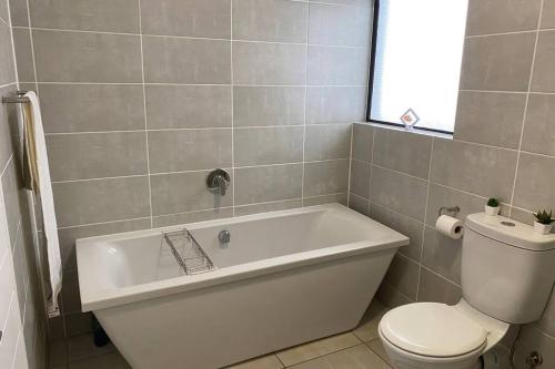 y baño con bañera blanca y aseo. en Penthouse 172 at The Blyde Crystal Lagoon en Pretoria