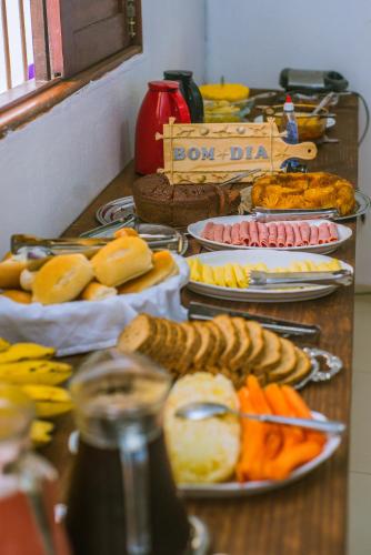een tafel gevuld met verschillende soorten voedsel op borden bij Pousada Casa Boa Milagres in Barra do Camaragibe
