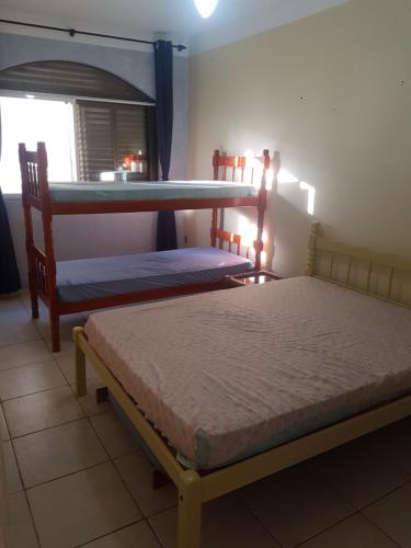 two bunk beds in a room with a window at Capao da canoa Apto. 3 dorm in Capão da Canoa