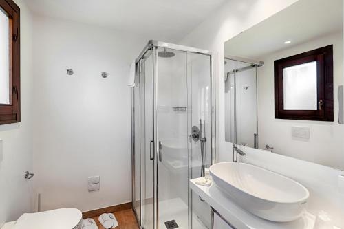 a white bathroom with a sink and a shower at Hotel Villa Mediterranea in Noto Marina