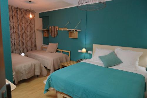 a blue bedroom with a bed and a chair at Hotel Arbre De Neu in Encamp