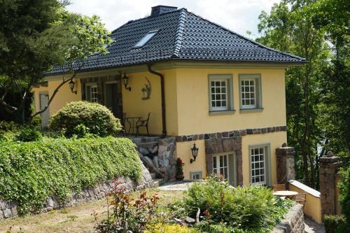 una casa gialla con tetto nero di Hanghaus der Villa Oderblick a Oderberg