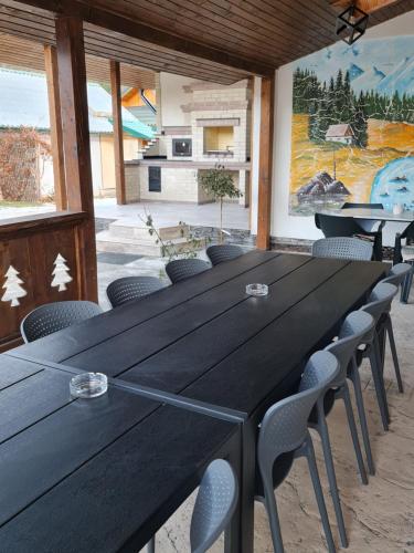 a large black table and chairs in a room at Chalet Mugure de Brad in Fundu Moldovei