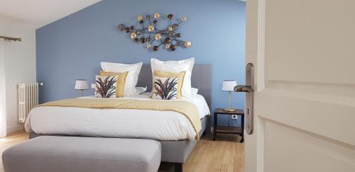 a bedroom with a large bed with a blue wall at Le Rempart du Midi in Angoulême