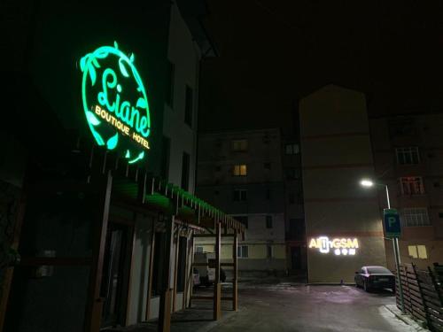 a neon sign on the side of a building at night at LIANE BOUTIQUE HOTEL in Câmpulung Moldovenesc