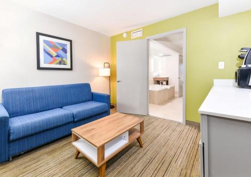 uma sala de estar com um sofá azul e uma mesa em Holiday Inn Express Hotel & Suites Pigeon Forge, an IHG Hotel em Pigeon Forge