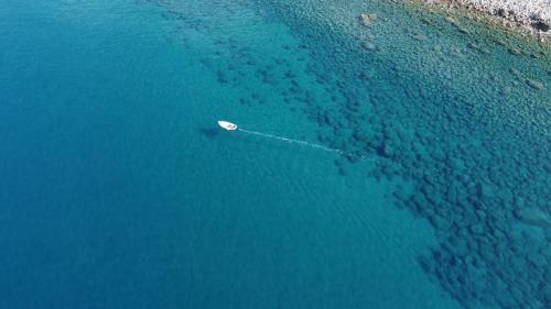 una vista aerea di una barca in acqua di Resort Baia del Silenzio a Pisciotta