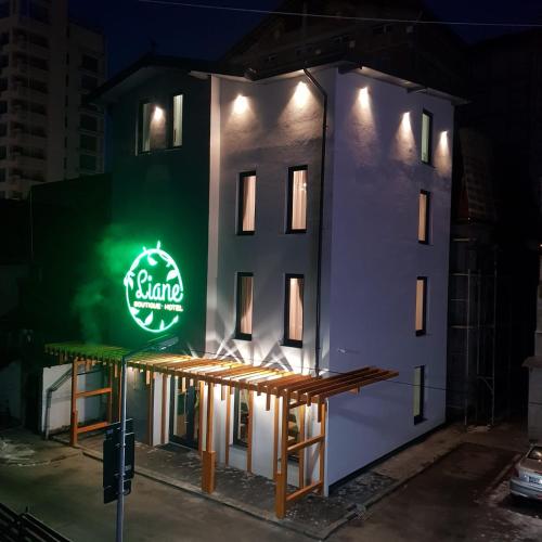 a building with a neon sign on the side of it at LIANE BOUTIQUE HOTEL in Câmpulung Moldovenesc