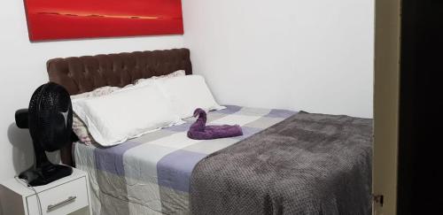 Un dormitorio con una cama con zapatos morados. en COBERTURA COM PISCINA, en Florianópolis