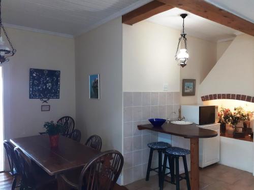 a kitchen and dining room with a table and chairs at Cottons Cottages in Simonʼs Town