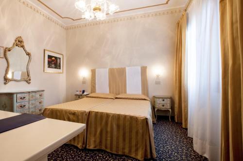 a hotel room with two beds and a mirror at Hotel Principe in Venice