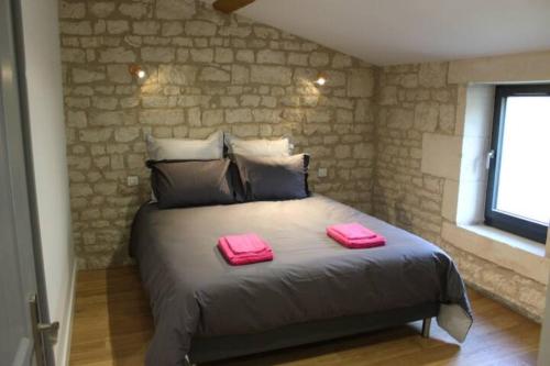a bedroom with a bed with two pink towels on it at Château des Loups - Les Cèdres Bleus in Échiré