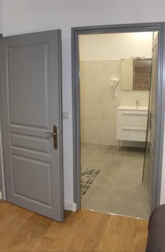a door leading to a bathroom with a sink at Château des Loups - Les Cèdres Bleus in Échiré