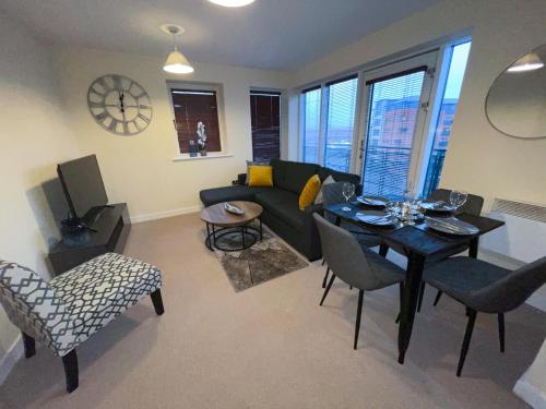 uma sala de estar com um sofá, uma mesa e cadeiras em Station Side Penthouse em Wolverhampton
