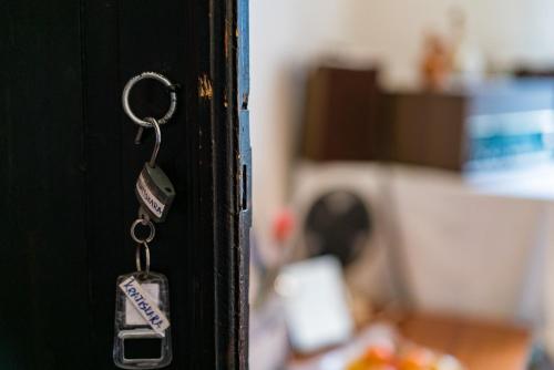 a pair of keys hanging from a black door at Etno House Shancheva in Kratovo