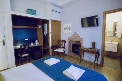 a bedroom with a bed and a desk and a fireplace at Navona Residenza de Charme in Rome