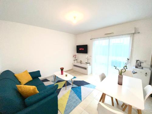 ein Wohnzimmer mit einem blauen Sofa und einem Tisch in der Unterkunft Appartement la plage de la pointe rouge in Marseille