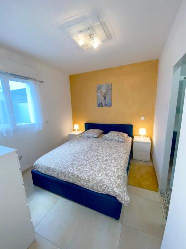 - une chambre avec un lit bleu et deux lampes dans l'établissement Appartement la plage de la pointe rouge, à Marseille