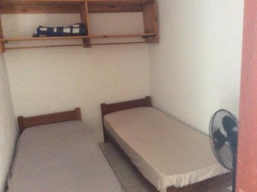 een kleine kamer met 2 bedden en een ventilator bij Pousada do Mar in Rio Grande