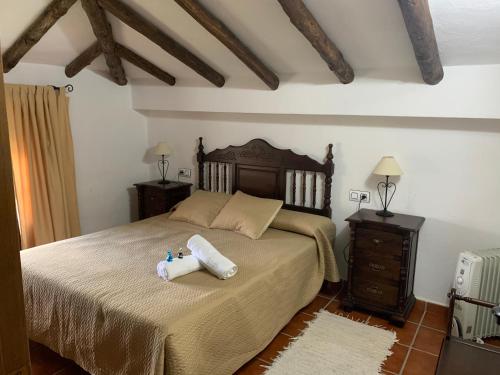 ein Schlafzimmer mit einem Bett mit zwei Kissen darauf in der Unterkunft CASAS RURALES MOLINO LA ERMITA in Zahara de la Sierra