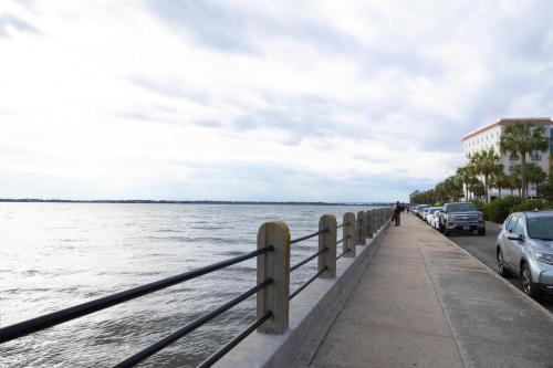 un marciapiede accanto a uno specchio d'acqua con auto parcheggiate di 195 East Bay a Charleston