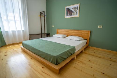 1 dormitorio con 1 cama grande con marco de madera en svaneti apartment's, en Mestia