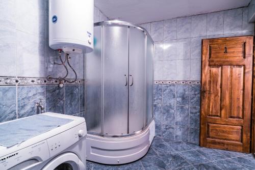 a bathroom with a shower and a washing machine at Etno House Shancheva in Kratovo