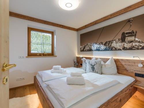 a large white bed in a room with a painting on the wall at Chalet Weinberg Top 1 & Top 2 by Apartment Managers in Kirchberg in Tirol