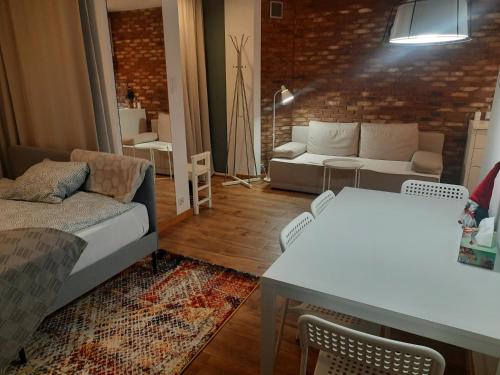 sala de estar con sofá y mesa en Apartament Młynarska - indywidualny dostęp, en Piaseczno