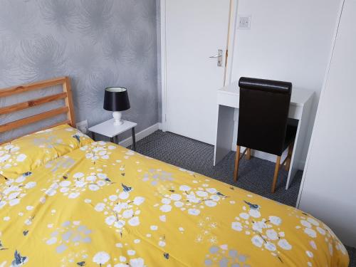 ein Schlafzimmer mit einem gelben Bett mit Blumen darauf in der Unterkunft Wonderland Guest House in Coventry