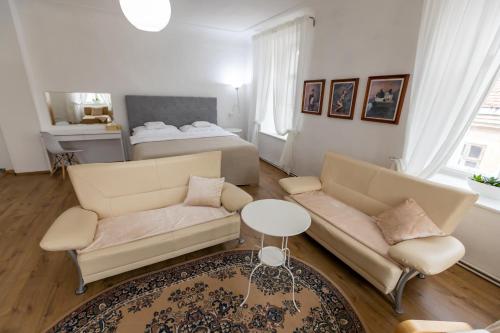 a living room with two couches and a bed at Palác Daun - Studio Apartments in Znojmo