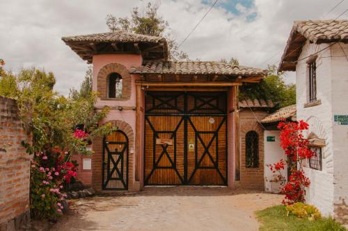 an entry to a house with a large wooden door at Hacienda Jimenita Wildlife Reserve in Puembo