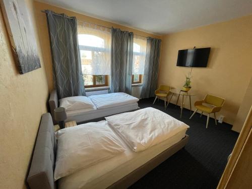 a hotel room with two beds and a tv at FeWo Nietleben in Halle an der Saale