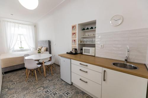 a kitchen with a sink and a table at Palác Daun - Studio Apartments in Znojmo