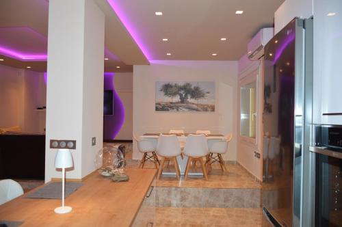 a dining room with a table and some purple lighting at Villa Kristi in Loutrá Elevtherón
